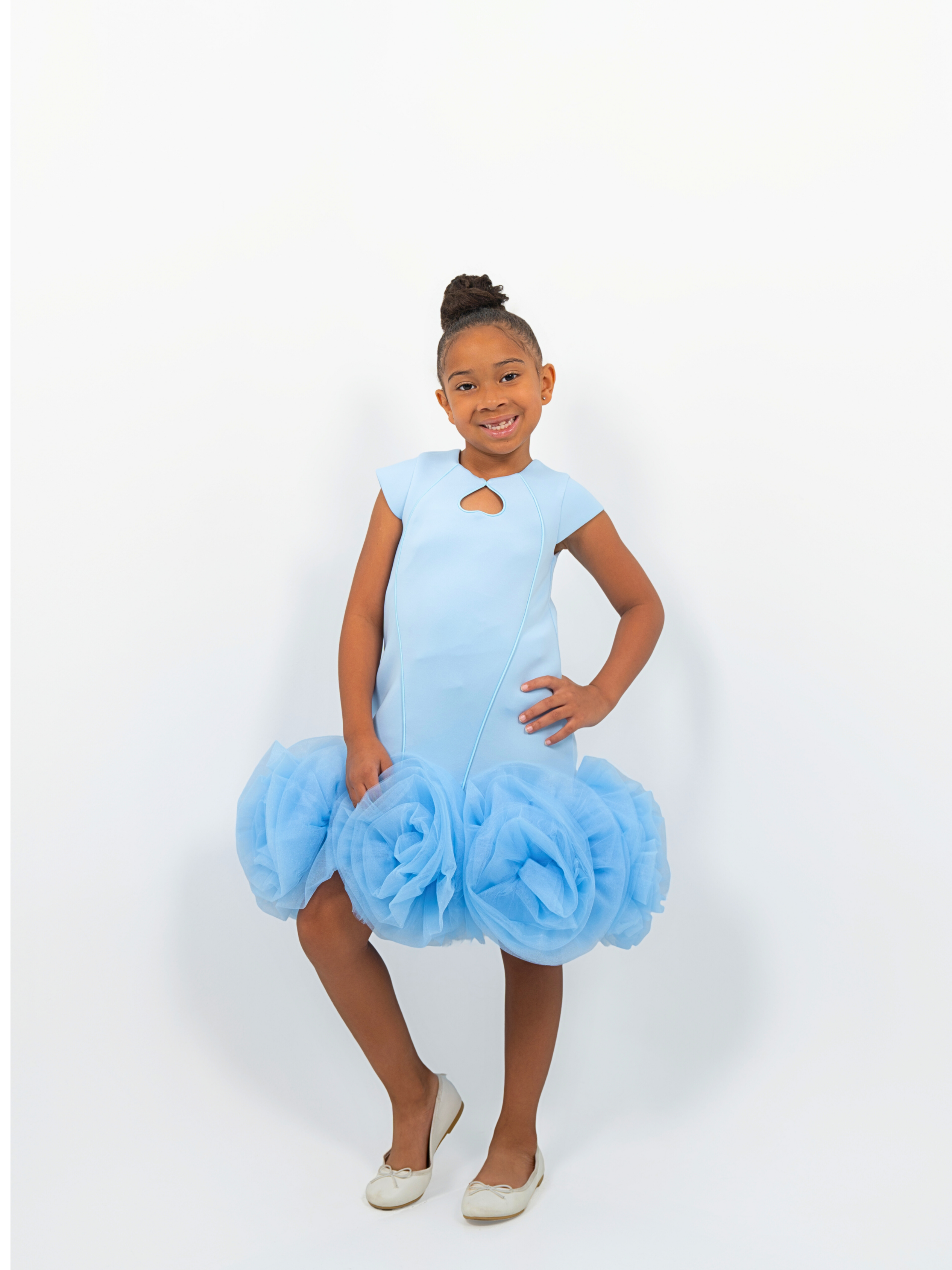 Girl wearing light blue puff-ball dress with keyhole neckline, ideal for birthdays or fashion shoots